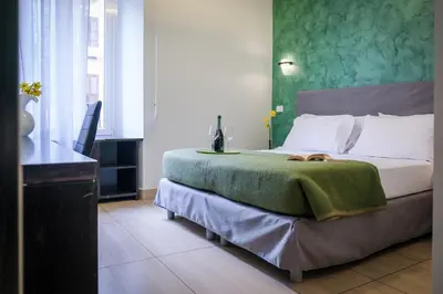 a bedroom with a bed with a green wall at Mocenigo Vatican Suites in Rome