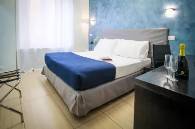 a bedroom with a bed with a blue wall at Mocenigo Vatican Suites in Rome