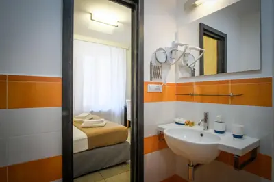 a bathroom with a sink and a bed at Mocenigo Vatican Suites in Rome
