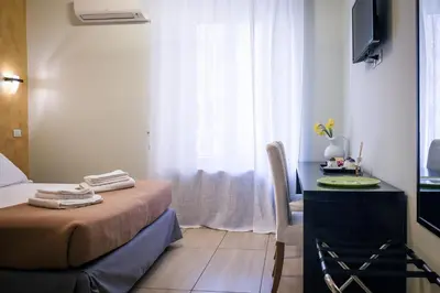 a bedroom with a bed and a desk and a window at Mocenigo Vatican Suites in Rome