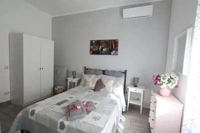 a white bedroom with a bed and two white cabinets at Pietro's house in Rome