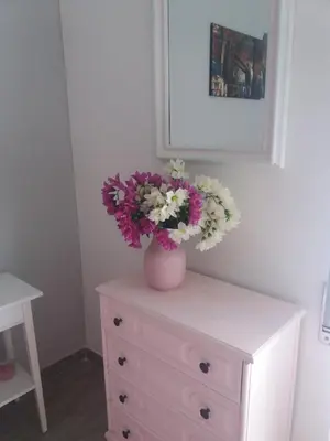 a vase with flowers on top of a dresser at Pietro's house in Rome