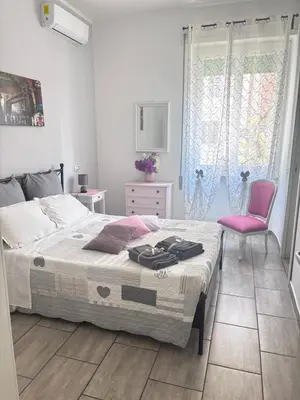 a bedroom with a bed and a pink chair at Pietro's house in Rome