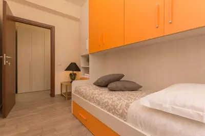 a bedroom with orange cabinets and a bed with two pillows at Il Giardino degli Agrumi - Roma in Rome