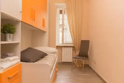 a small bedroom with a bed and a chair at Il Giardino degli Agrumi - Roma in Rome