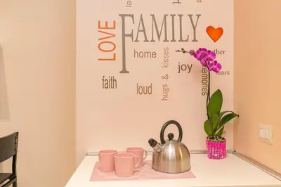 a table with pink cups and a tea kettle at Il Giardino degli Agrumi - Roma in Rome