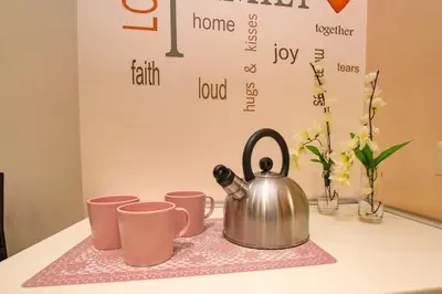 a tea kettle sitting on a table with pink cups at Il Giardino degli Agrumi - Roma in Rome
