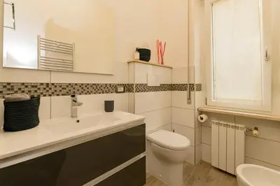 a white bathroom with a toilet and a sink at Il Giardino degli Agrumi - Roma in Rome