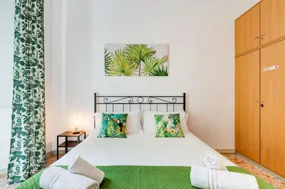 a bedroom with a white bed with a green blanket at Tasso Street 102 in Rome