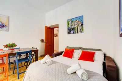 a bedroom with a bed with red and white pillows at Tasso Street 102 in Rome
