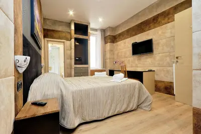 a bedroom with a bed and a tv on a wall at Gialli Vatican Guesthouse in Rome