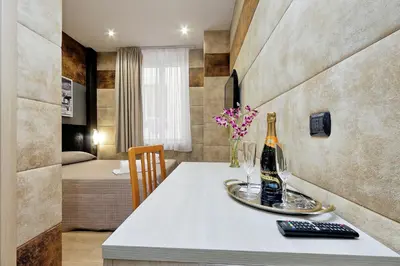 a room with a table with a bottle of champagne at Gialli Vatican Guesthouse in Rome