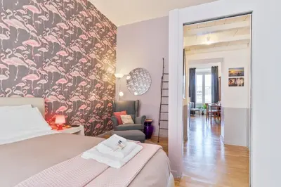 a bedroom with a bed and a chair in a room at Rome As You Feel - Vittorio Colorful Design Apartment in Rome