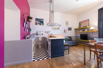 a kitchen and living room with a table and chairs at Rome As You Feel - Vittorio Colorful Design Apartment in Rome