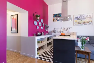 a kitchen with pink and white walls and a counter at Rome As You Feel - Vittorio Colorful Design Apartment in Rome
