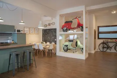a kitchen and a living room with a scooter in a window at Rhome Vintage Holidays San Pietro in Rome