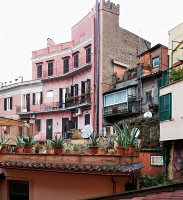 a group of buildings with potted plants on a building at Roma center Fori Imperiali Raffy's charming Suite in Rome