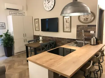 a kitchen with a wooden counter top and a table at THE BREAK - Via Veneto Charming Suite in Rome