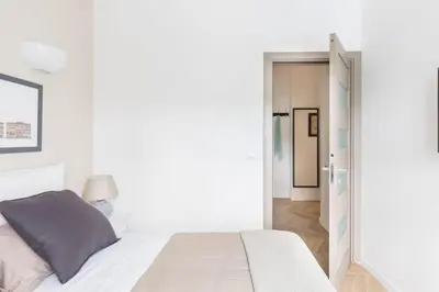 a white bedroom with a bed and a doorway at THE BREAK - Via Veneto Charming Suite in Rome
