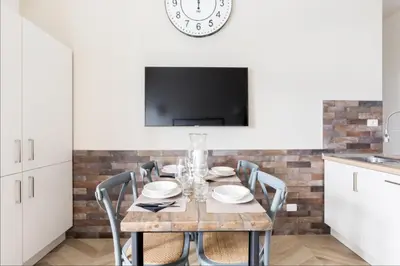 a dining room with a table with chairs and a tv at THE BREAK - Via Veneto Charming Suite in Rome