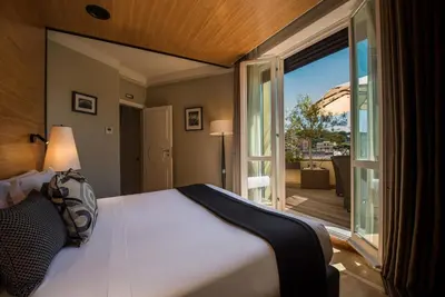 a bedroom with a large bed and a large window at 47 Boutique Hotel in Rome