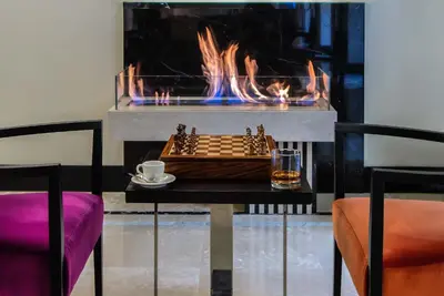 a chess board and a drink on a table with a fireplace at 47 Boutique Hotel in Rome