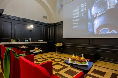 a room with a projection screen and red chairs at 47 Boutique Hotel in Rome