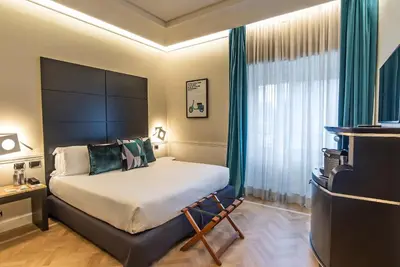a bedroom with a large bed and a television at 47 Boutique Hotel in Rome