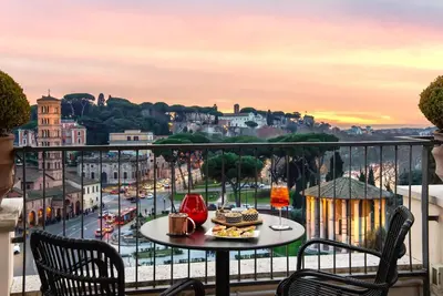 a table with food on a balcony with a view of a city at 47 Boutique Hotel in Rome