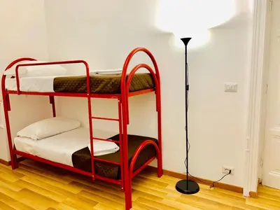 a red bunk bed in a room with a lamp at COMFORT INN ROMA TERMINI in Rome