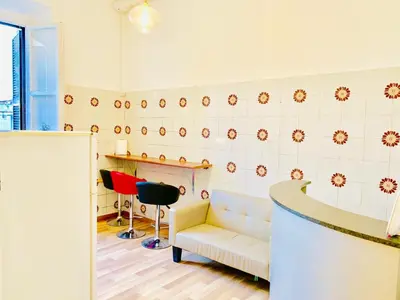 a waiting room with a white couch and a stool at COMFORT INN ROMA TERMINI in Rome