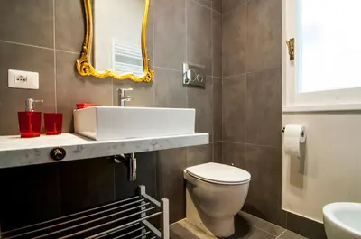 a bathroom with a toilet and a sink and a mirror at GuestHost - Vatican Museums Cozy Flat x4 in Rome