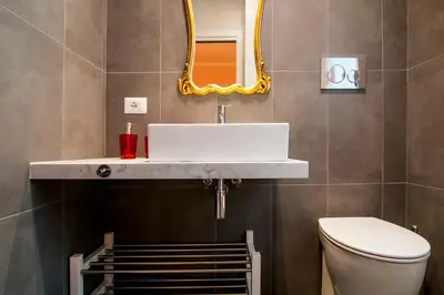 a bathroom with a sink and a toilet and a mirror at GuestHost - Vatican Museums Cozy Flat x4 in Rome