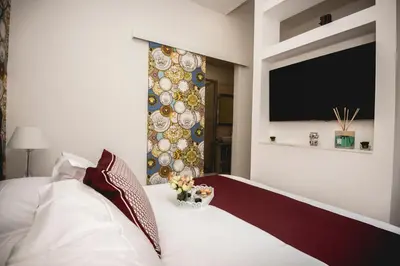 a bedroom with a bed with a tv on the wall at PRATI 1930 Boutique apartments Rome in Rome