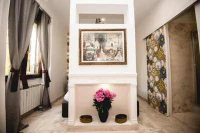 a living room with a fireplace with a vase of flowers at PRATI 1930 Boutique apartments Rome in Rome