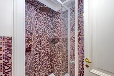a bathroom with a tiled shower with a glass door at Youroom Carrozze in Rome