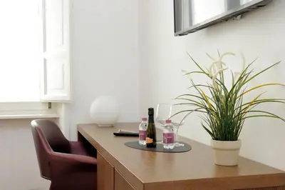 a table with two bottles of wine and a plant at Youroom Carrozze in Rome