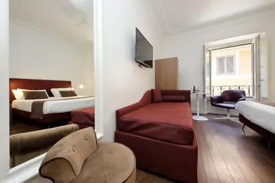 a hotel room with two beds and a couch at Youroom Carrozze in Rome