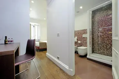 a room with a desk and a bathroom with a tub at Youroom Carrozze in Rome
