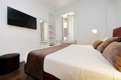 a bedroom with a large bed and a flat screen tv at Youroom Carrozze in Rome