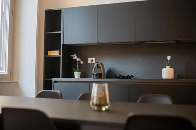 a kitchen with a table with chairs and cabinets at Youroom Abruzzi in Rome