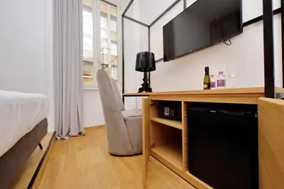 a bedroom with a bed and a desk with a television at Youroom Abruzzi in Rome