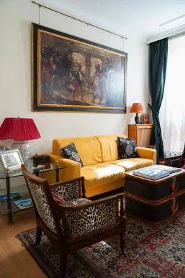 a living room with a yellow couch and chairs at Suite Borghese 42 in Rome