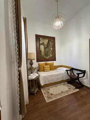 a living room with a couch and a chandelier at Colosseo Room in Rome