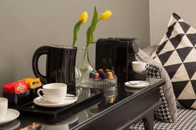 a coffee table with cups and a vase with flowers at Almaìt in Rome