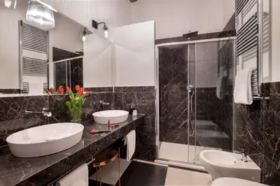 a black and white bathroom with two sinks and a shower at Almaìt in Rome