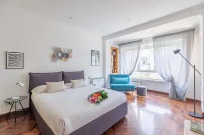 a bedroom with a bed and a blue chair at Vatican Cozy Apartment with Terrace in Rome