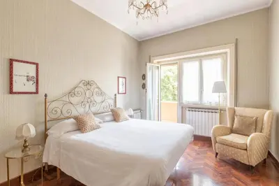 a bedroom with a white bed and a chair at Vatican Cozy Apartment with Terrace in Rome