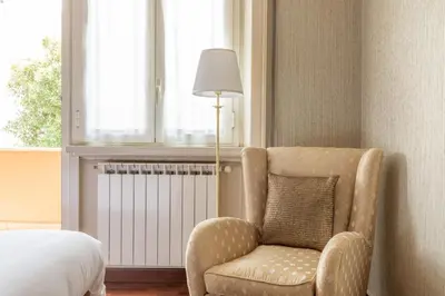a bedroom with a chair and a bed and a window at Vatican Cozy Apartment with Terrace in Rome