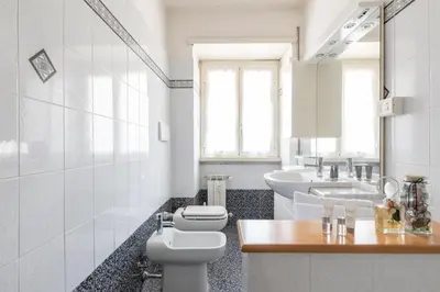 a white bathroom with a toilet and a sink at Vatican Cozy Apartment with Terrace in Rome